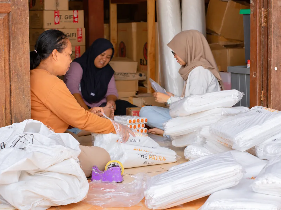 Kerja Sama Tim Pengemasan. Tim bekerja bersama menata dan mengemas barang pesanan.