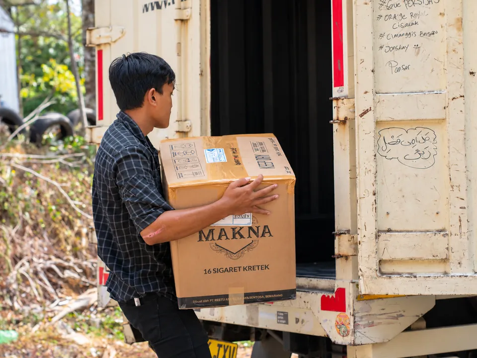 Pemindahan Barang ke Kendaraan. Kardus pesanan dipindahkan dari area penyiapan menuju kendaraan.